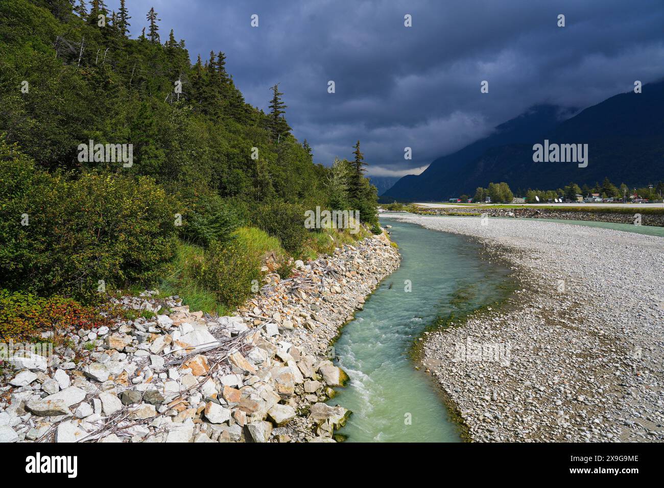Skagway river flowing into a fjord of southeast Alaska surrounded by ...