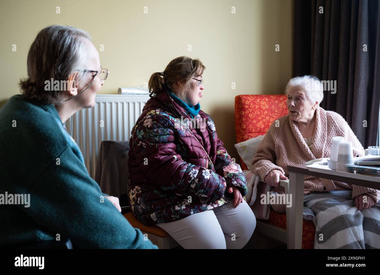 Tienen, Flanders, Belgium, November 11, 2022 - 85 and 95 old women having a conversation in an assited home with a Down Syndrome woman of 40 yo. Partially Model released. Stock Photo