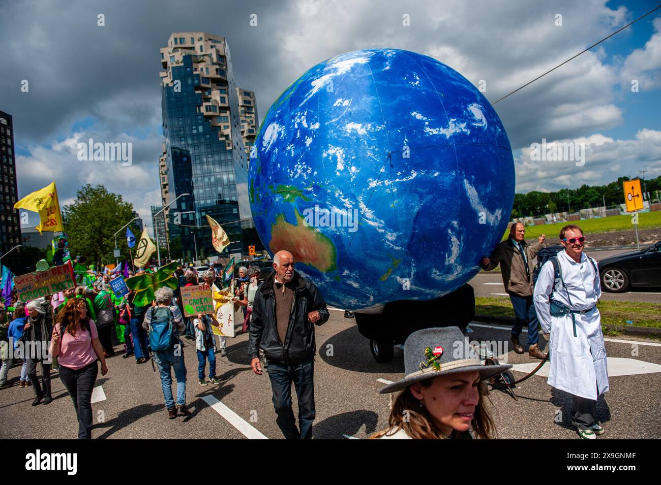 Amsterdam, Netherlands. 31st May, 2024. Protesters are seen walking with a big Earth balloon during the rally. Thousands of people gathered at the center of the financial heart of the Netherlands, in Amsterdam to stop billions in subsidies for fossil polluters. Several climate organizations want to demand a fair (climate) policy, just before the European elections. Credit: SOPA Images Limited/Alamy Live News Stock Photo