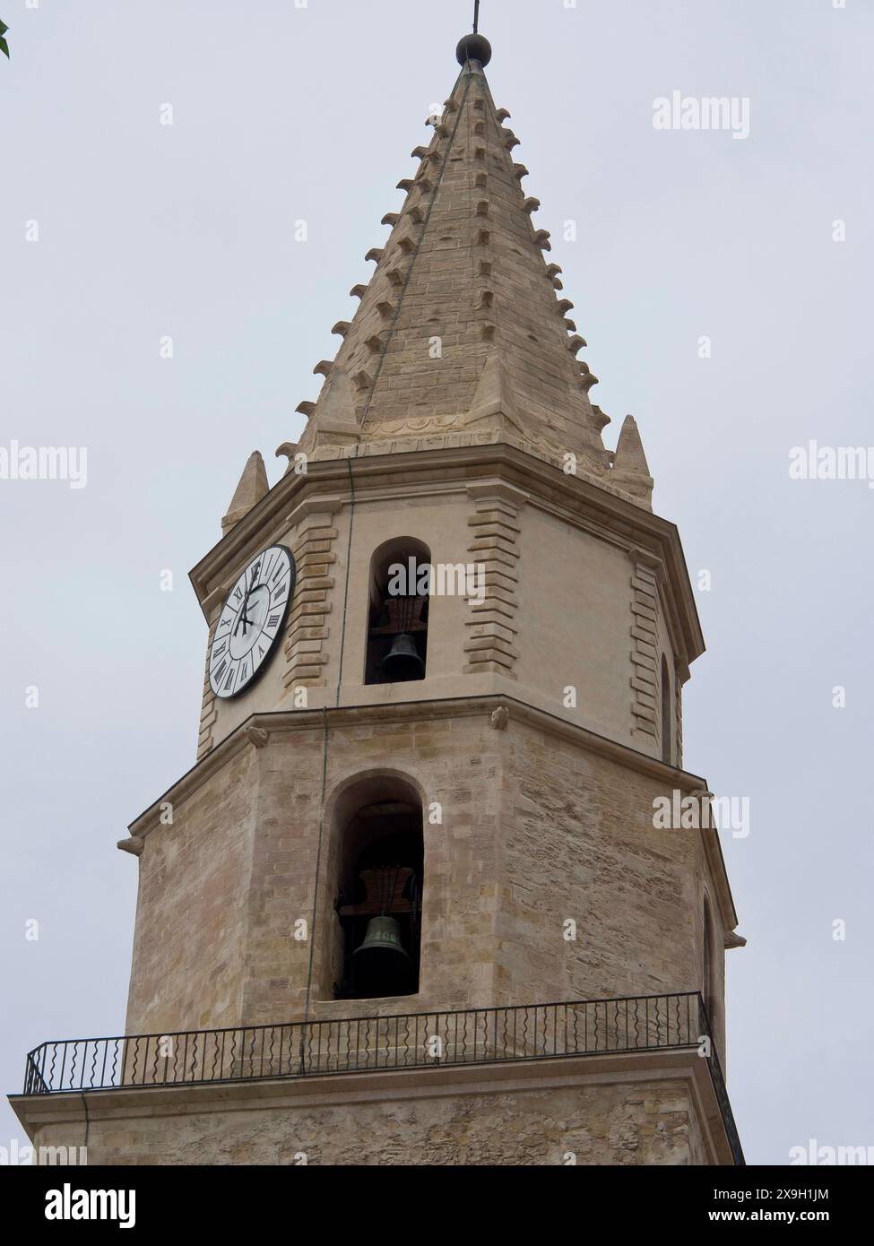 historic-sandstone-bell-tower-with-clock-and-bells-in-front-of-a-cloudy