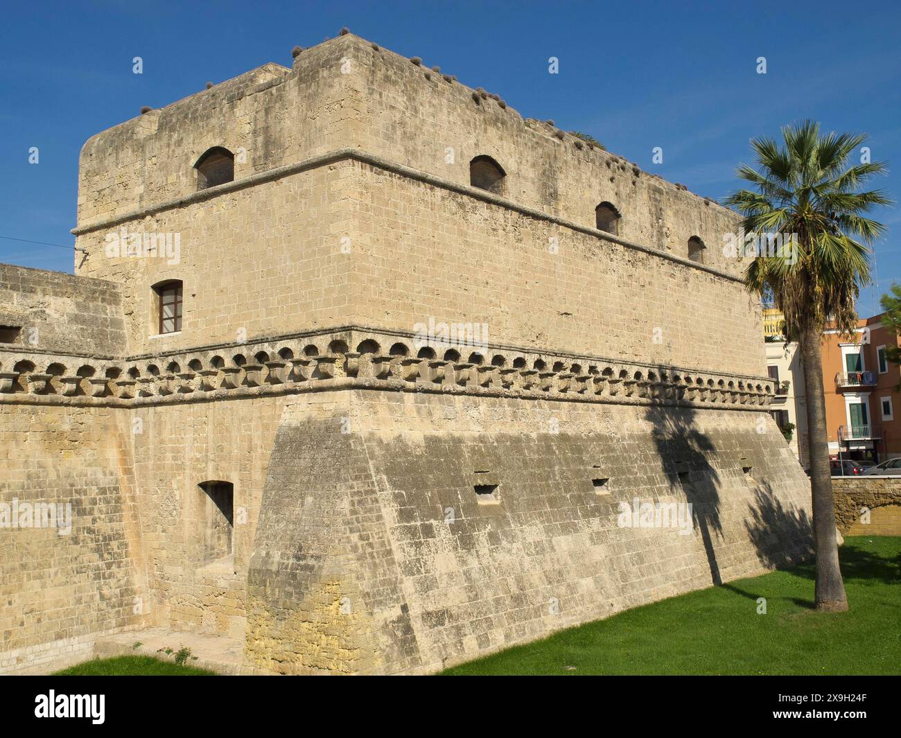 Old fortress with imposing stone walls and a palm tree in the ...