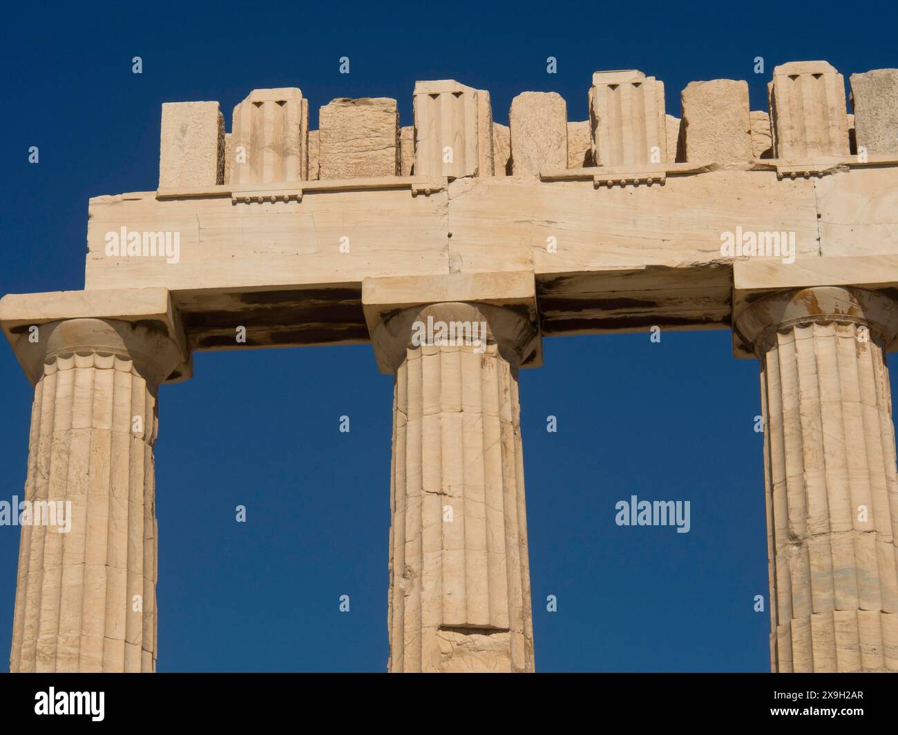 Detailed view of ancient columns of a temple under a clear blue sky ...