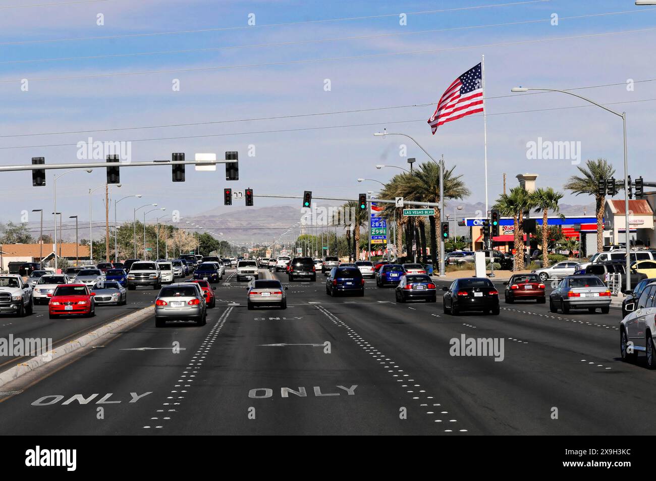 Las Vegas, Nevada, USA, North America, A busy street with cars, an American flag and shops in the background, Las Vegas Strip Stock Photo