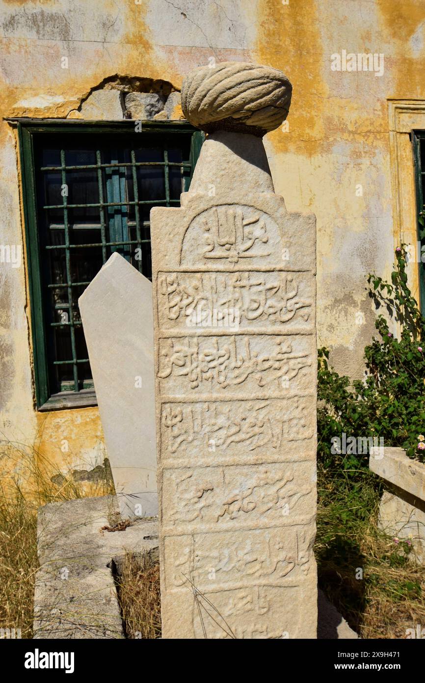 Turkish cemetery, Islamic cemetery, Mohammedan cemetery, Historic gravestone with inscriptions in front of an old, partly crumbling wall and windows Stock Photo
