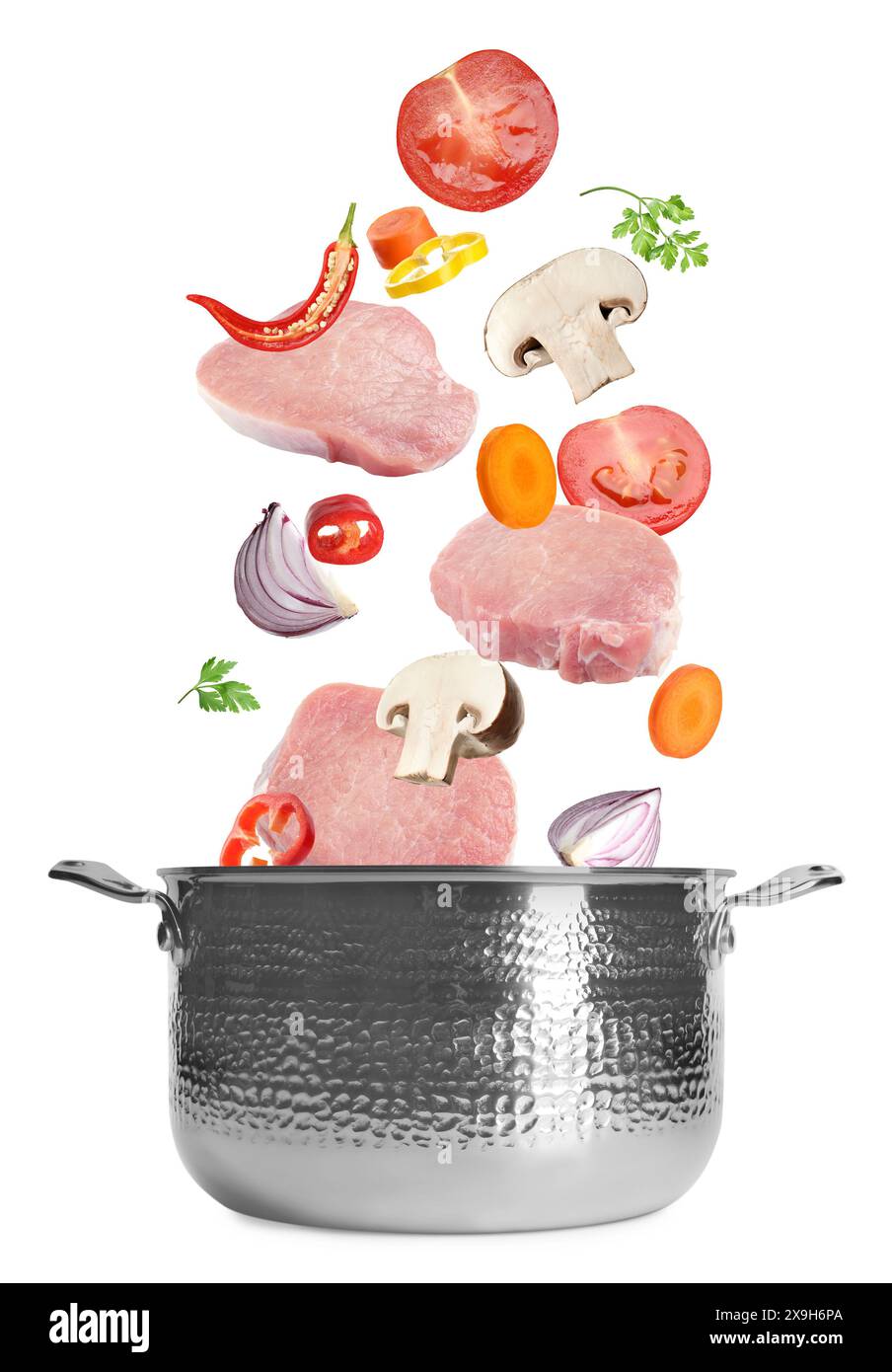 Fresh ingredients falling into saucepan on white background Stock Photo