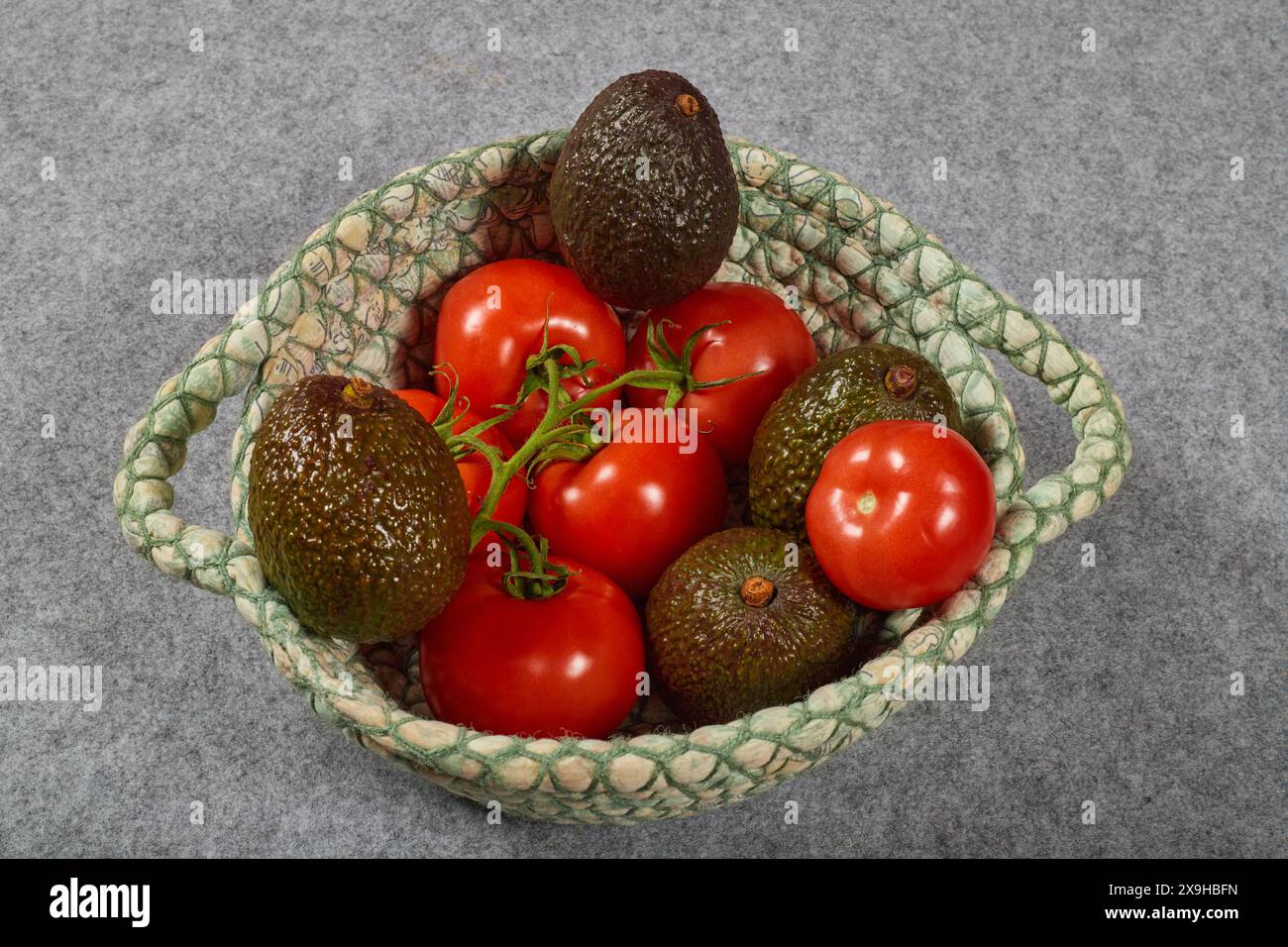 Organic potassium rich foods, Avocados, Bananas and Tomatoes. Healthy summer foods in a linen basket!!! Stock Photo