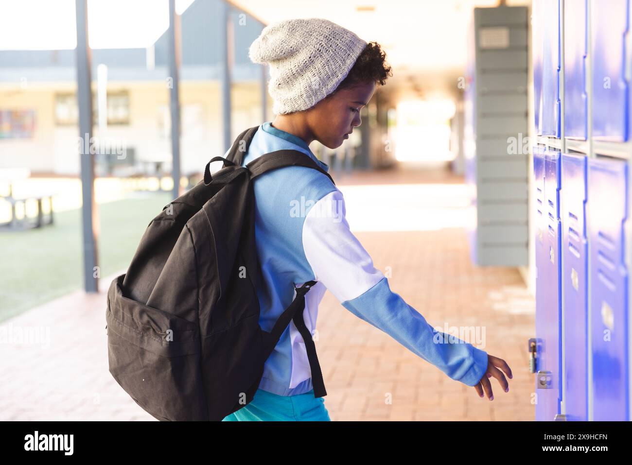 Biracial boy at school opens his locker Stock Photo - Alamy