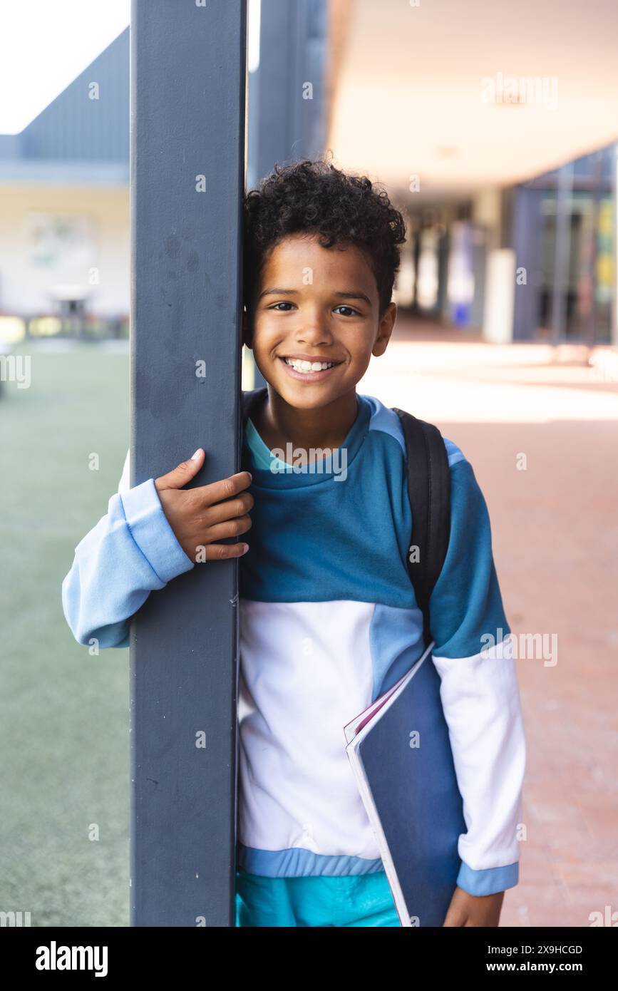 Biracial boy smiles outside a school building Stock Photo - Alamy