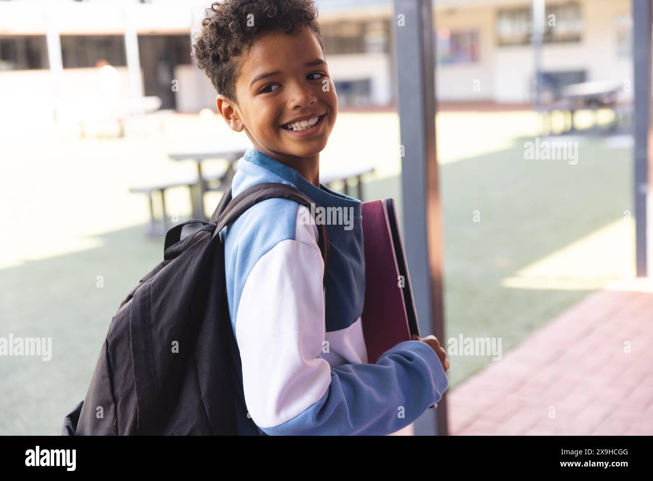 Biracial boy smiles at school, with copy space Stock Photo - Alamy