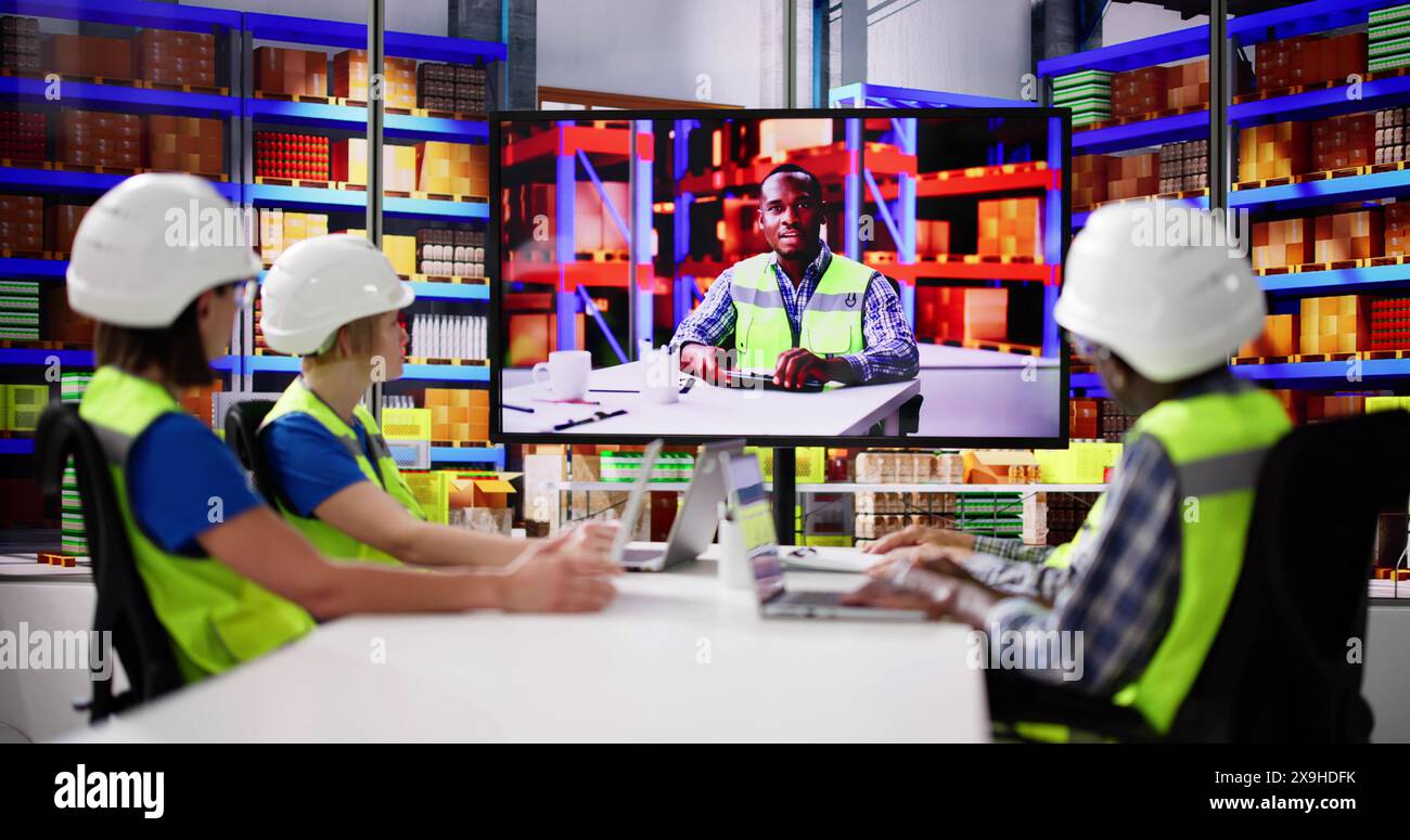 Warehouse Workers Having Video Conference With Man Stock Photo