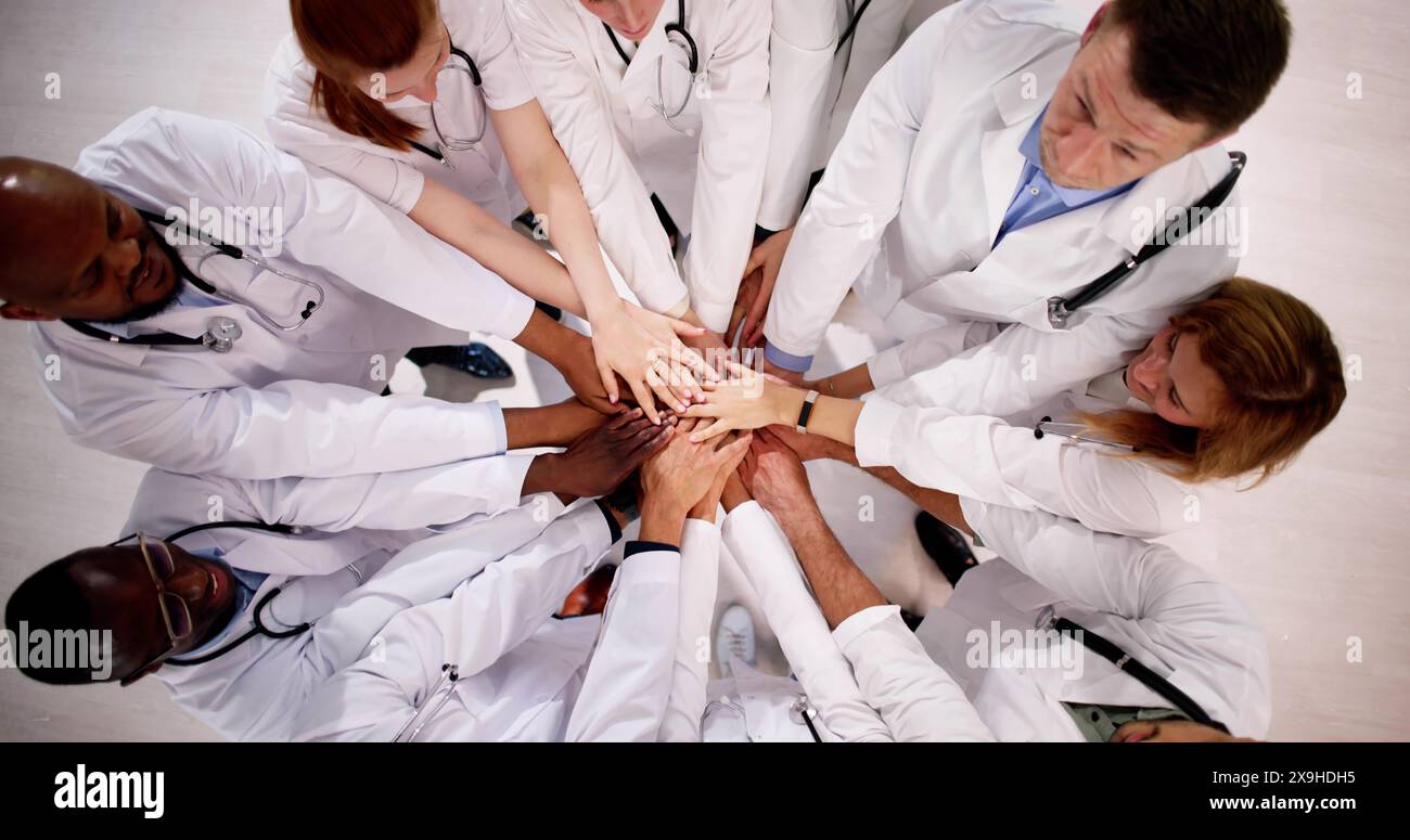 Medical Team Stacking Hands Against In Hospital Stock Photo