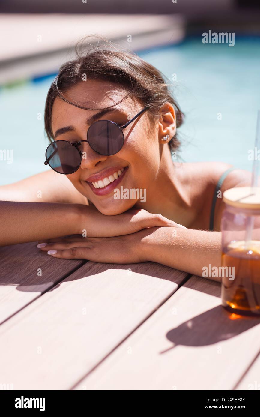 A biracial young female wearing sunglasses, relaxing outdoors Stock Photo