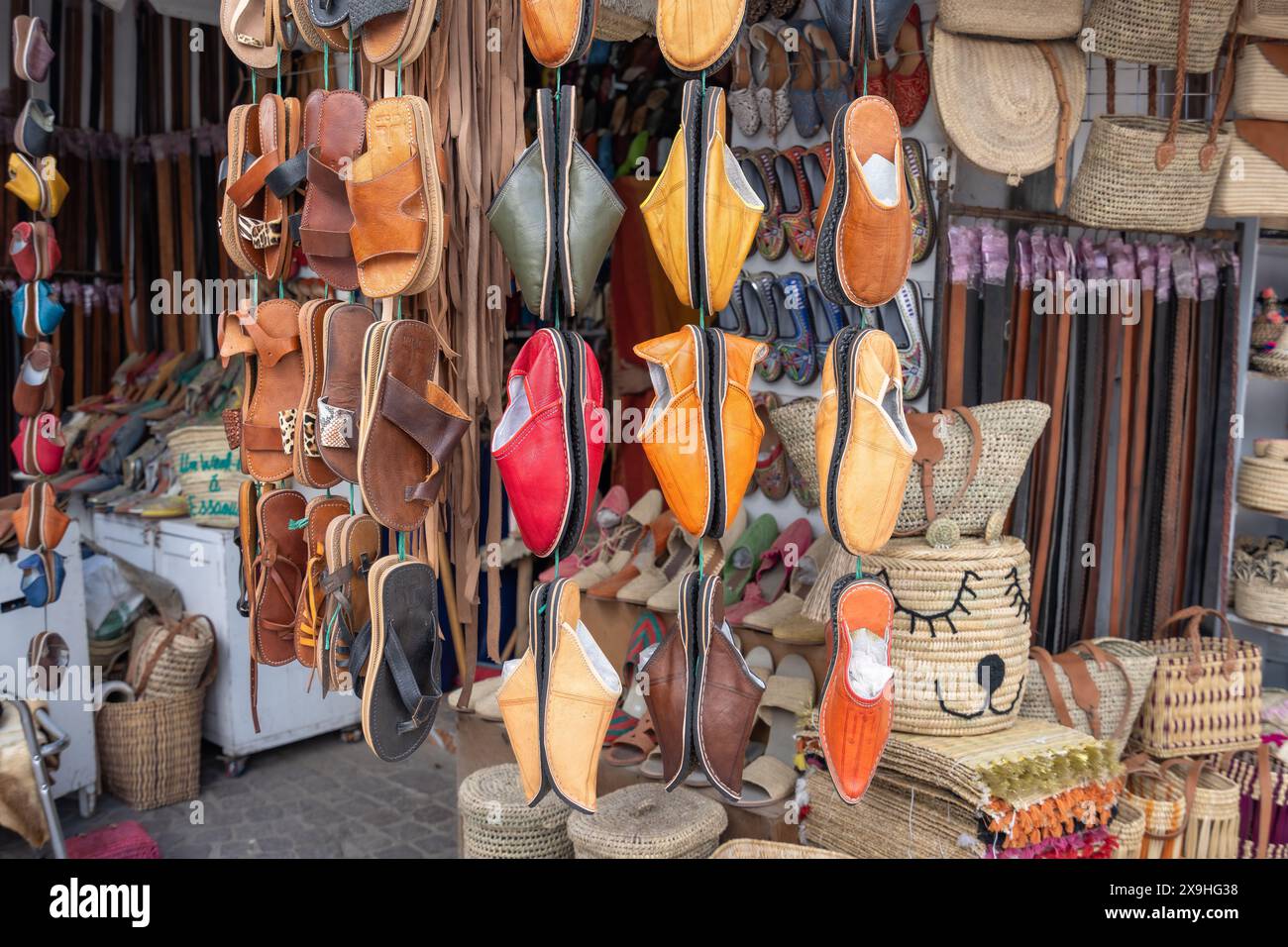 Essaouira, Morocco - March 17, 2024: A vibrant display of handmade leather shoes and belts captures the essence of local craft talent. Stock Photo