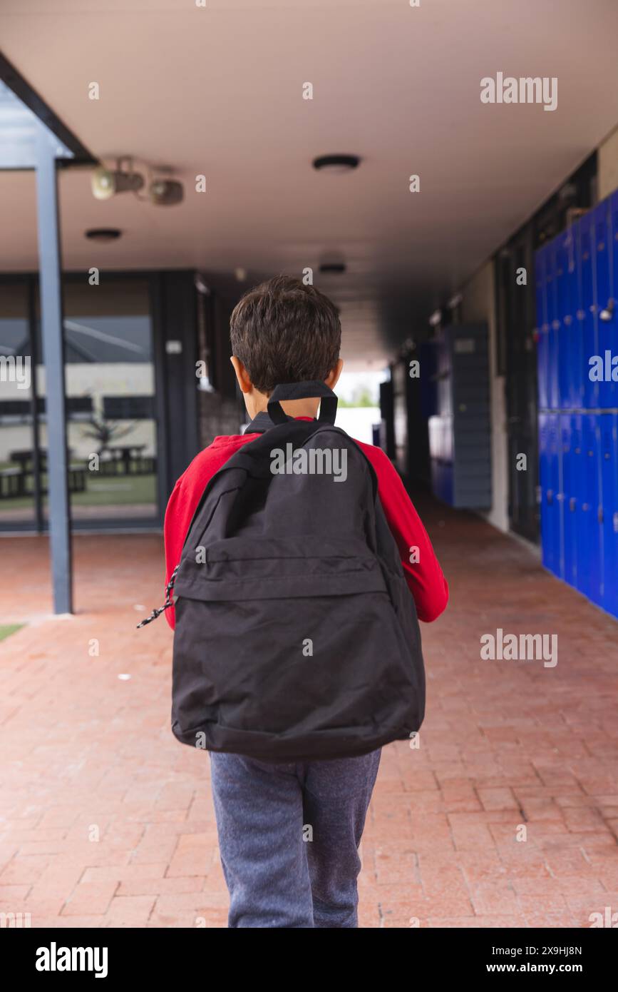 In school, young biracial male student is walking outdoors Stock Photo ...