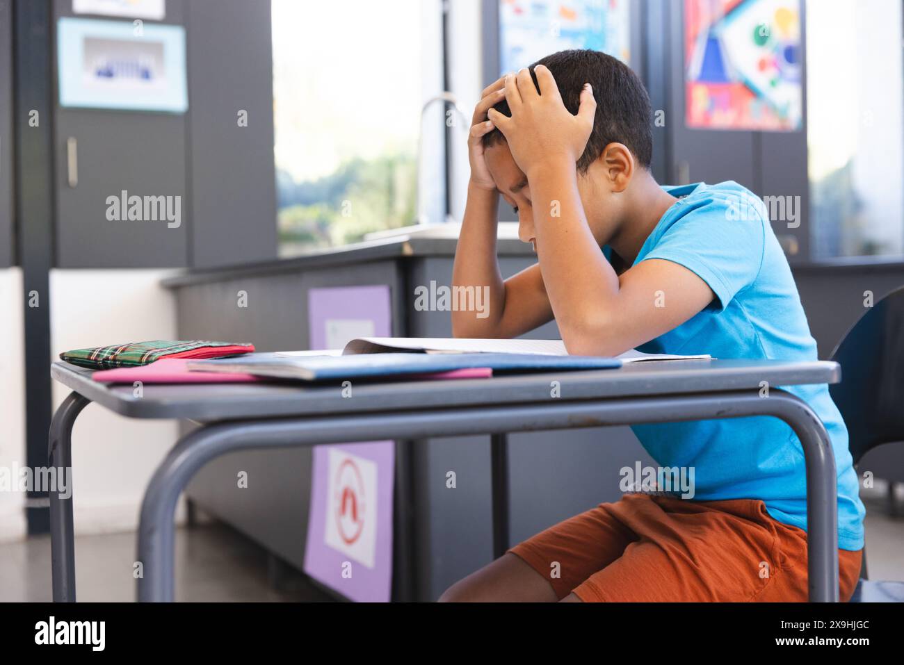 Biracial boy studying in a classroom at school, with copy space Stock ...