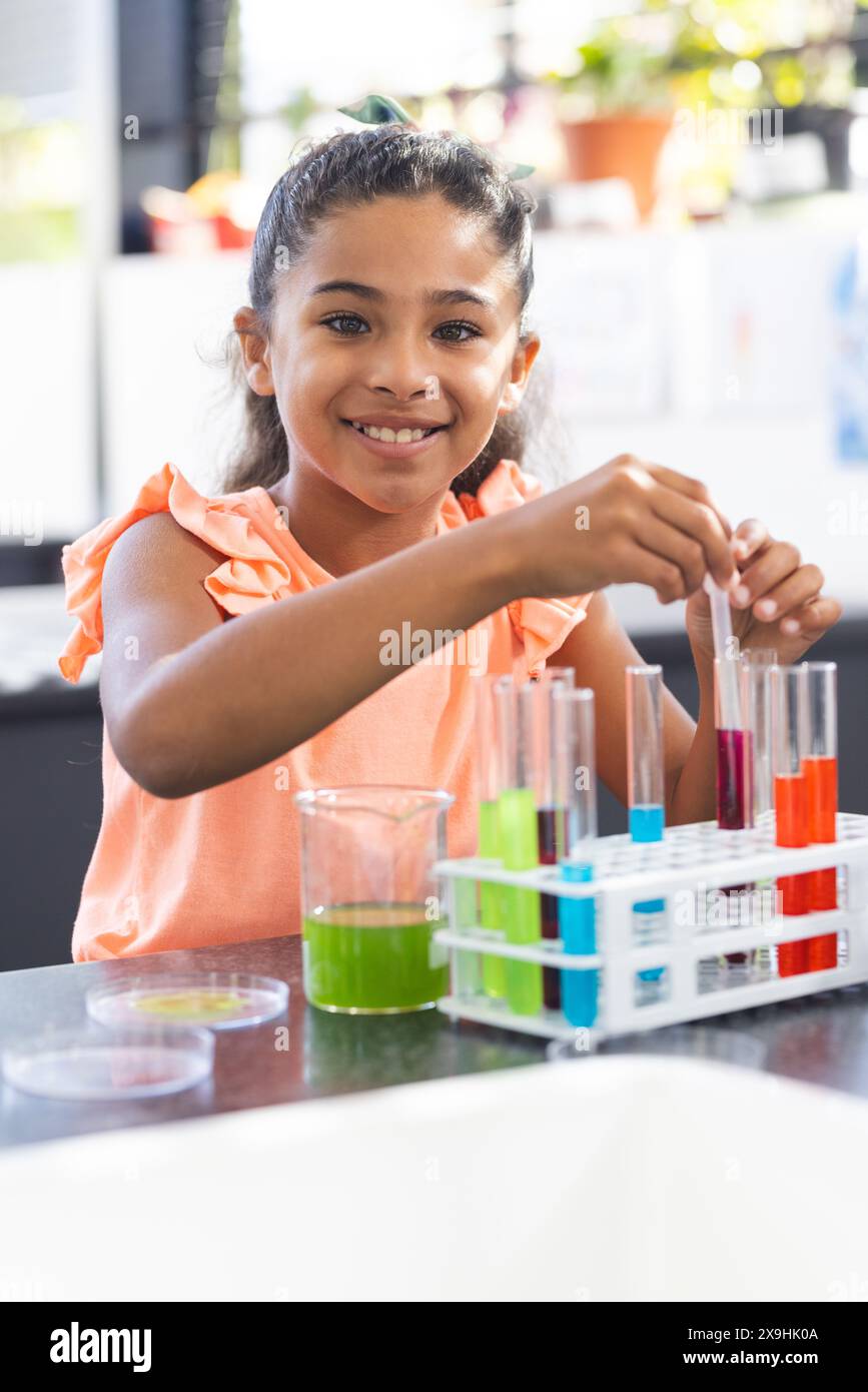 In school, young biracial female student is conducting a science experiment Stock Photo