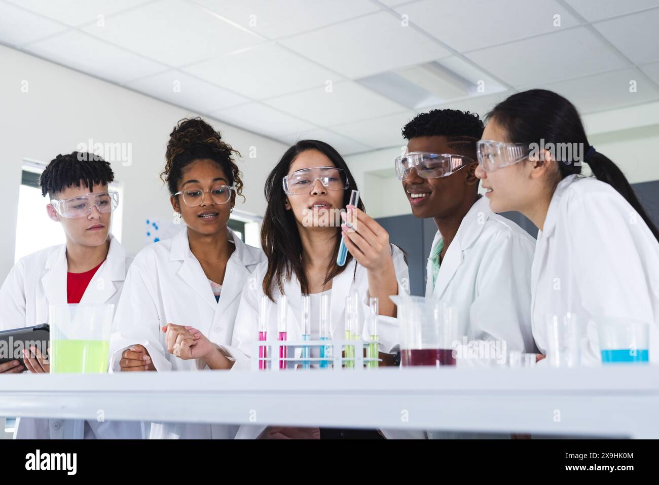 Diverse students engage in a science experiment at high school Stock Photo