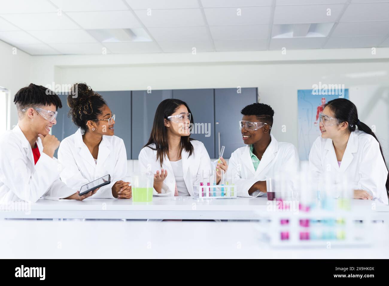 Diverse students engage in a science experiment at high school Stock Photo