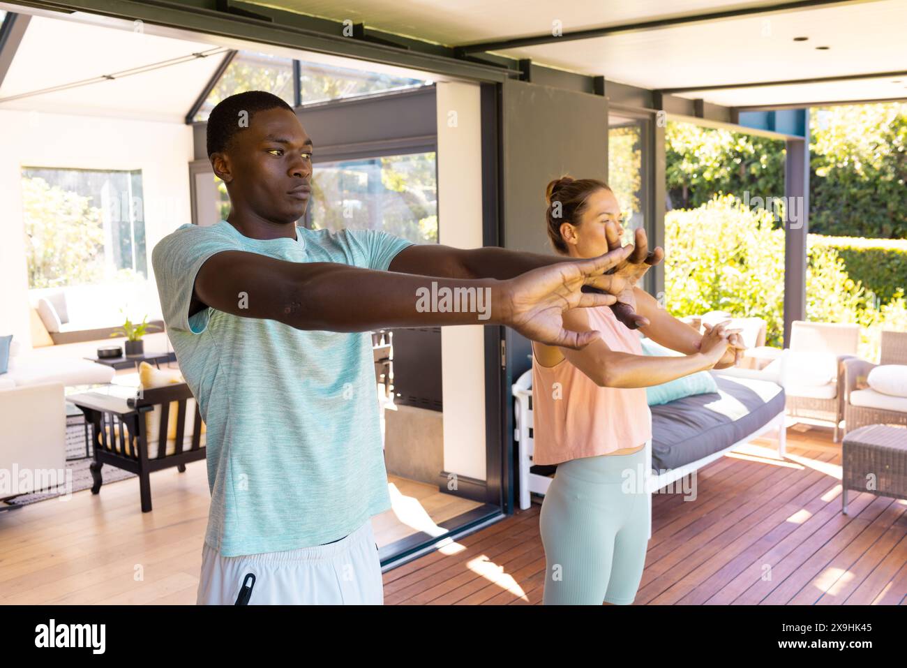 A diverse young couple practicing yoga outside Stock Photo