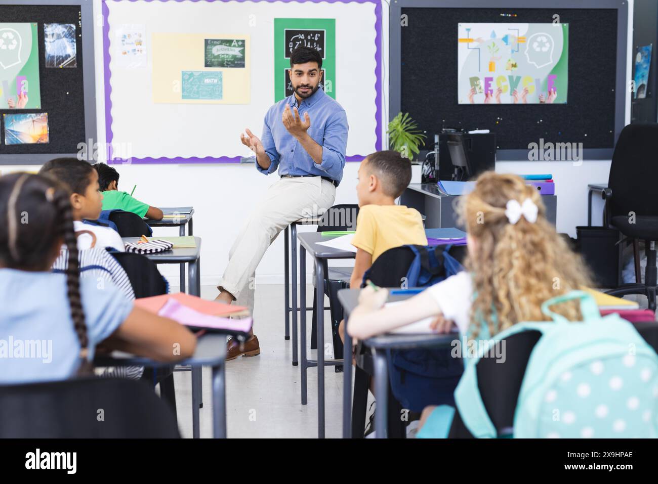 A young Asian male teacher guides diverse group of kids Stock Photo - Alamy