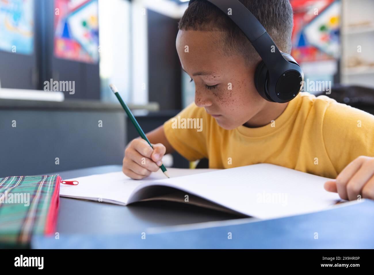Biracial boy studies intently at school Stock Photo