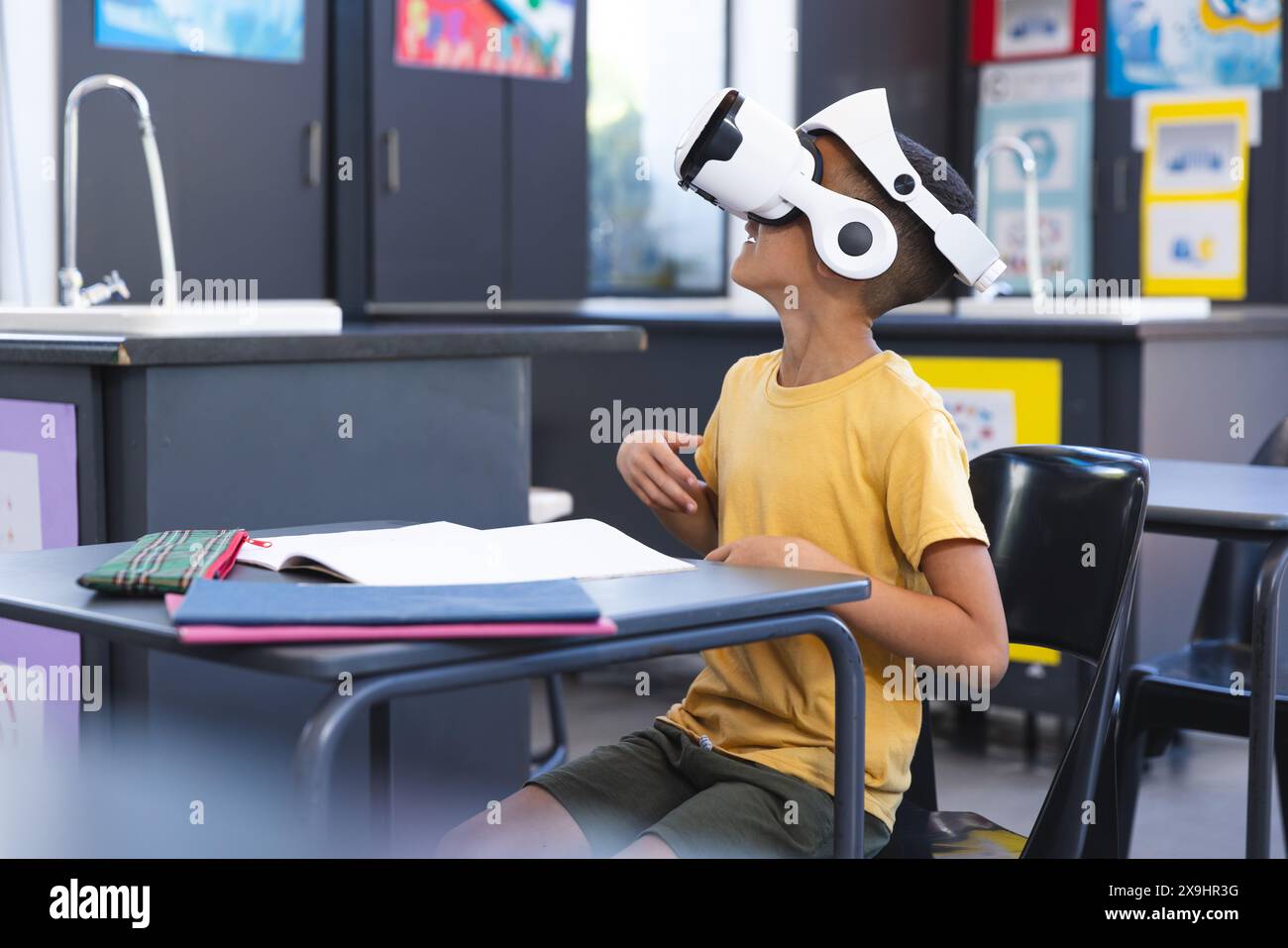 Biracial boy explores virtual reality in school Stock Photo