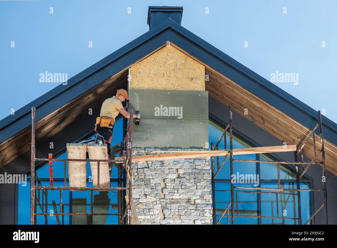 Construction Worker Installing Stone Veneer on a Modern Home Stock Photo