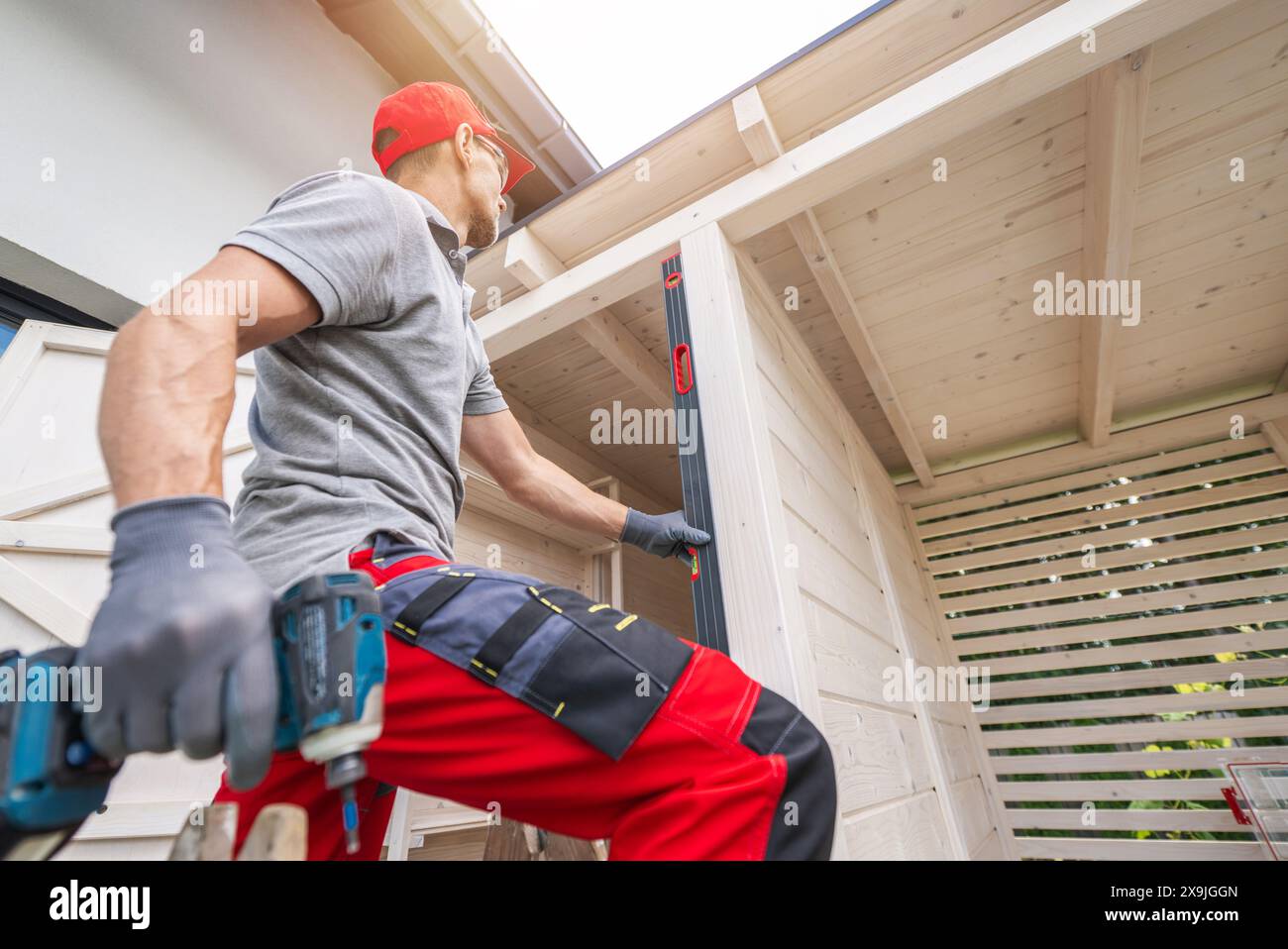 Caucasian Construction Worker Using Level on Wooden Structure Stock Photo