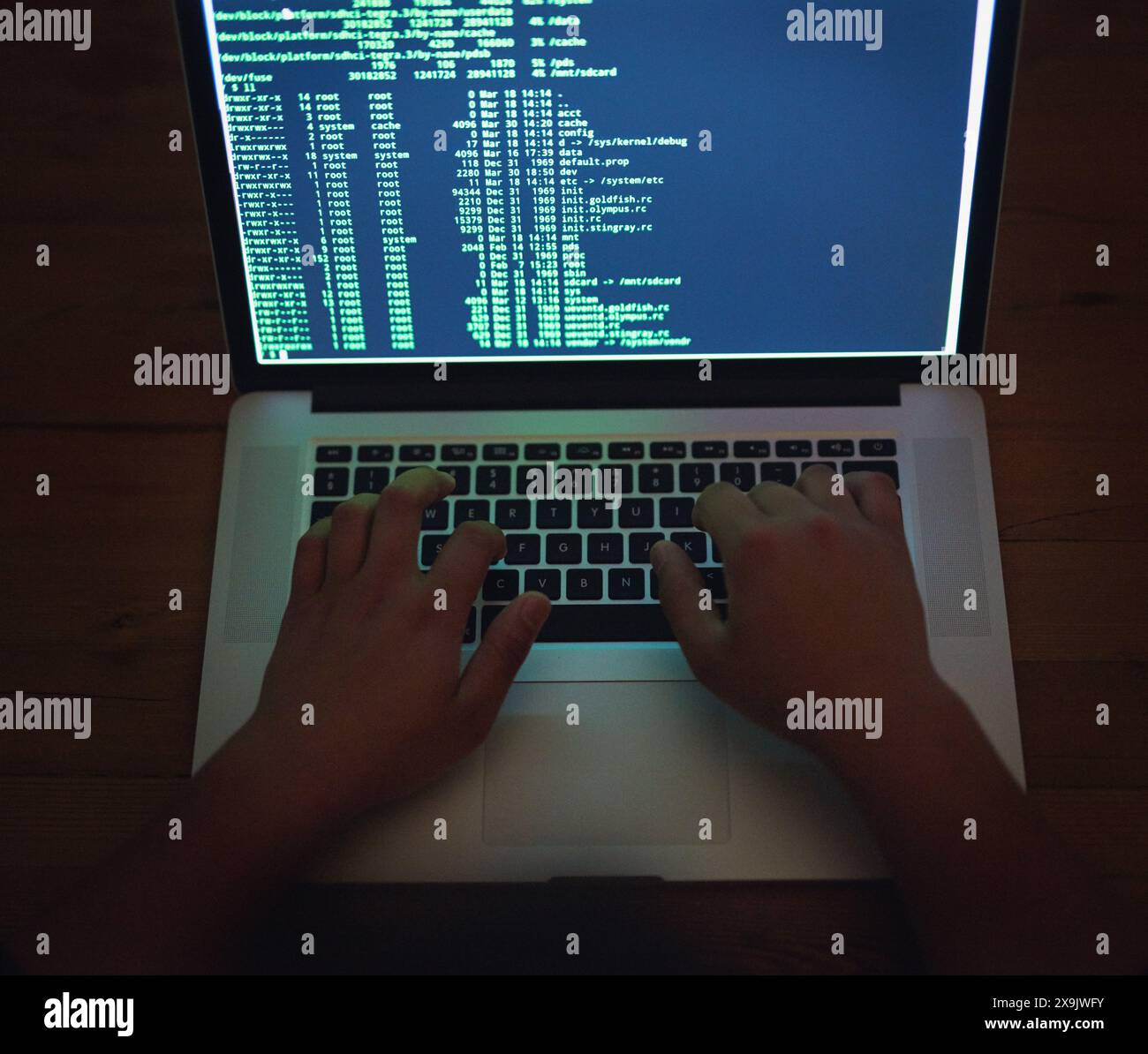 Coding, hands and hacker on laptop at night as malware thief for hacking database software, hardware virus or firewall error. Spy, typing or criminal Stock Photo