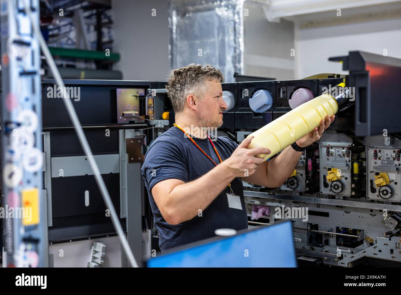 Maintenance engineer in a in printing house fixing machine Stock Photo