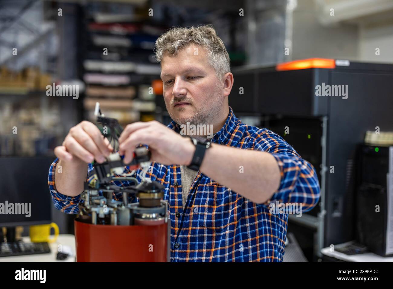 Maintenance engineer in a in printing house fixing machine Stock Photo