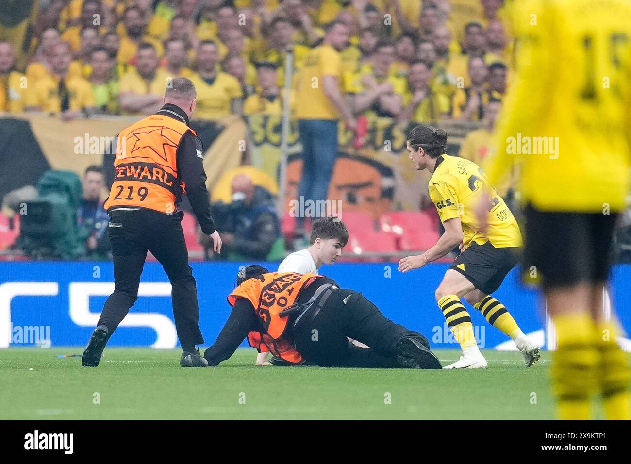 a-pitch-invader-is-tackled-by-stadium-stewards-during-the-uefa