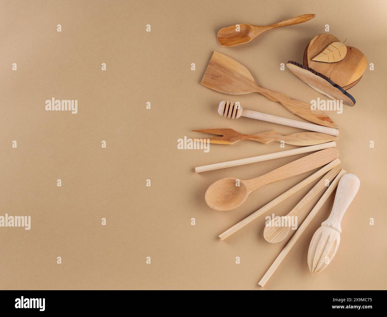 Wooden Cutlery Set with Spatula, Spoon, Bamboo Straws, Manual Juicer and Honey Stick on Beige Background Stock Photo