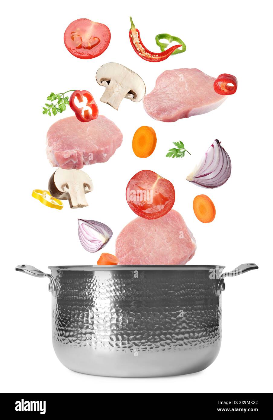 Fresh ingredients falling into saucepan on white background Stock Photo