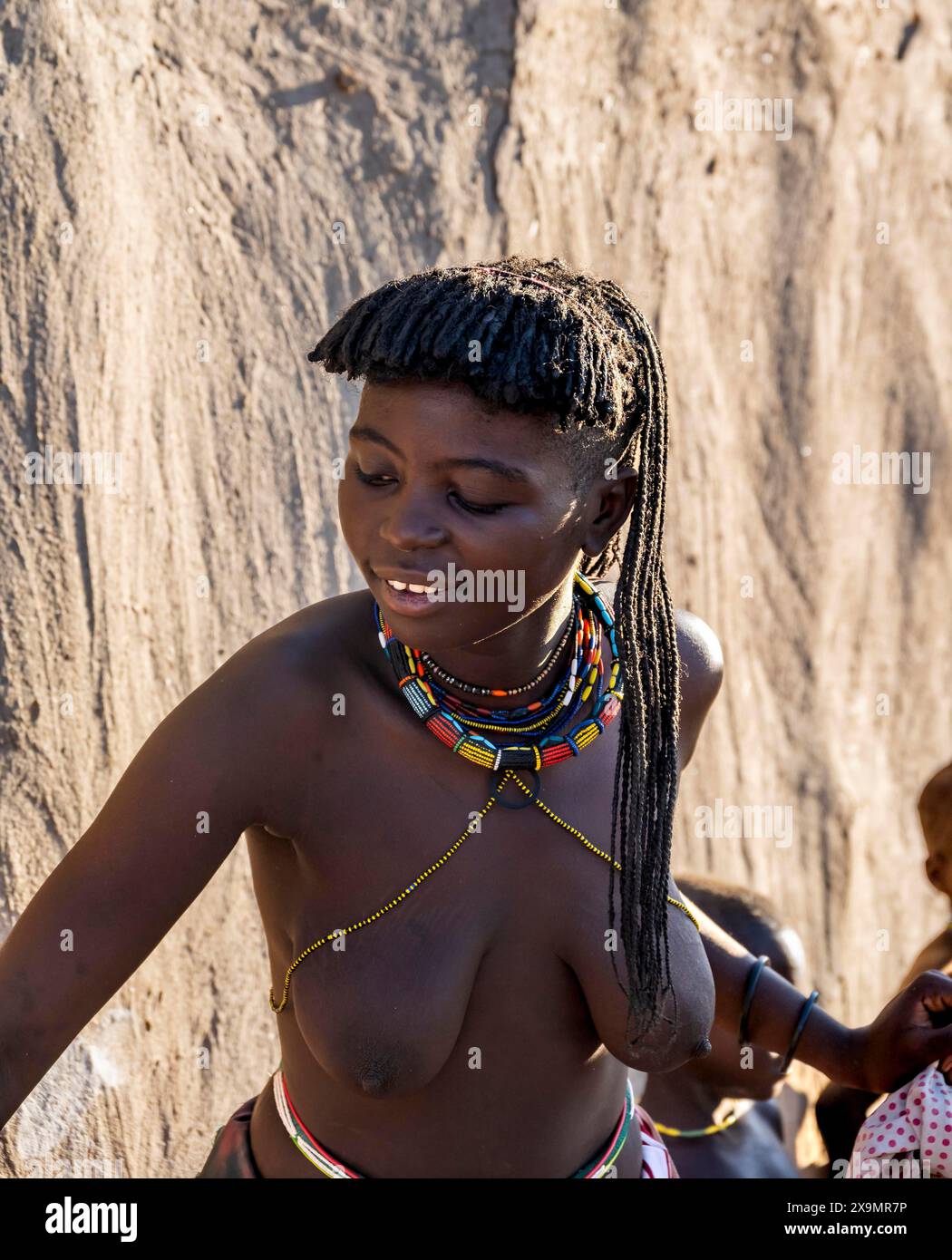 Two young traditional Hakaona woman with colourful necklaces, in the morning light, Angolan tribe of the Hakaona, near Opuwo, Kunene, Namibia Stock Photo