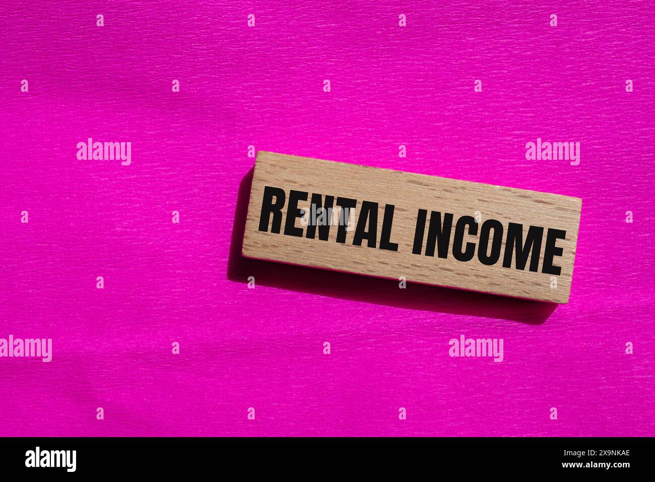Rental income words written on wooden block with pink background ...