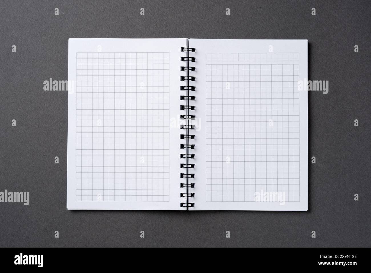 Checkered and spiral notebook on a dark gray table Stock Photo