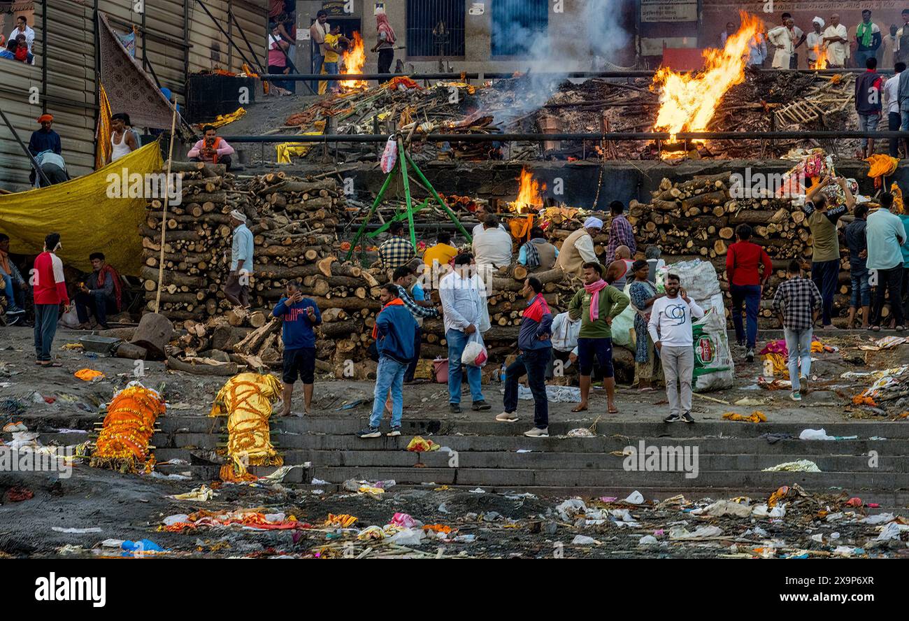 Bustling scene of an openair cremation ritual by a river with attendants and mourners Stock Photo