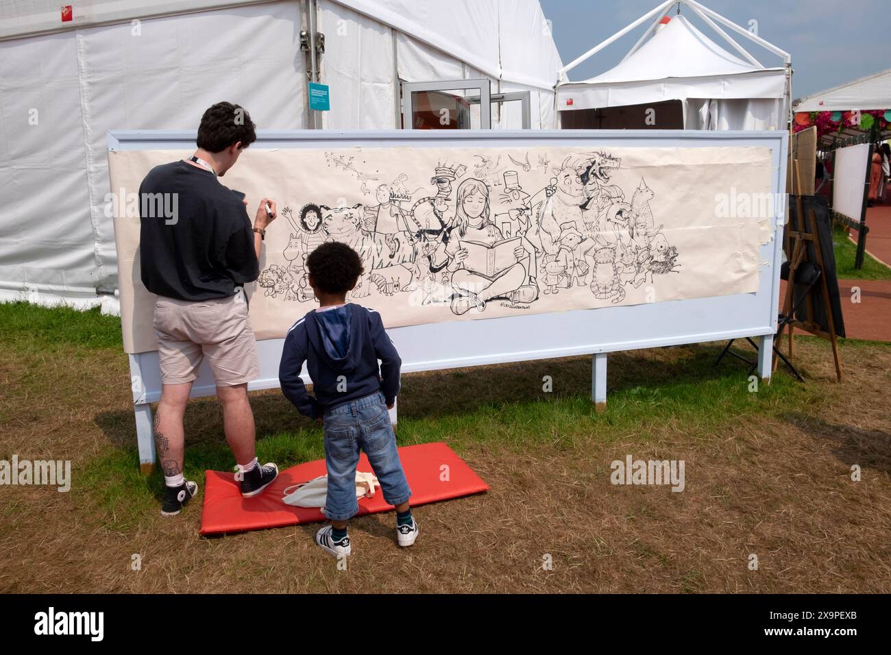 Boy watching artist Liam Saunders draw characters from childrens books