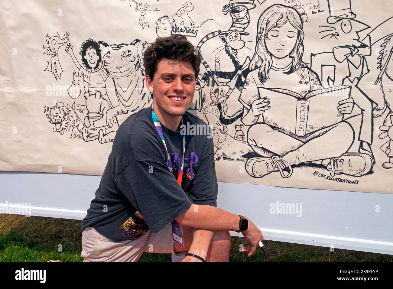 Artist Liam Saunders drawing a tableau characters from childrens books in family area at Hay Book Festival site 2024 Hay-on-Wye Wales UK KATHY DEWITT Stock Photo