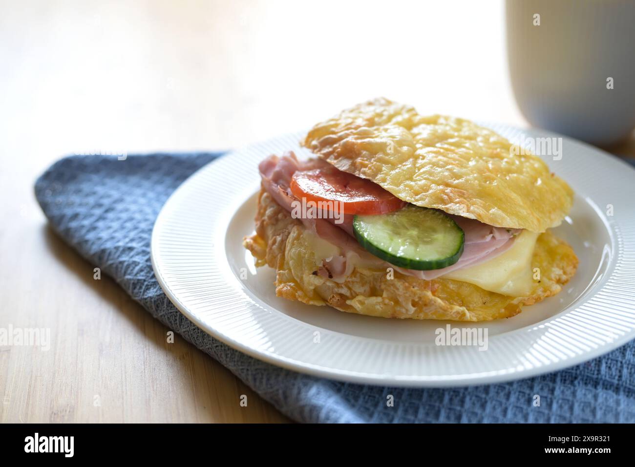 Cheese roll sandwich with boiled turkey, tomato and cucumber on a plate as a lunch snack, copy space, selected focus, narrow depth of field Stock Photo