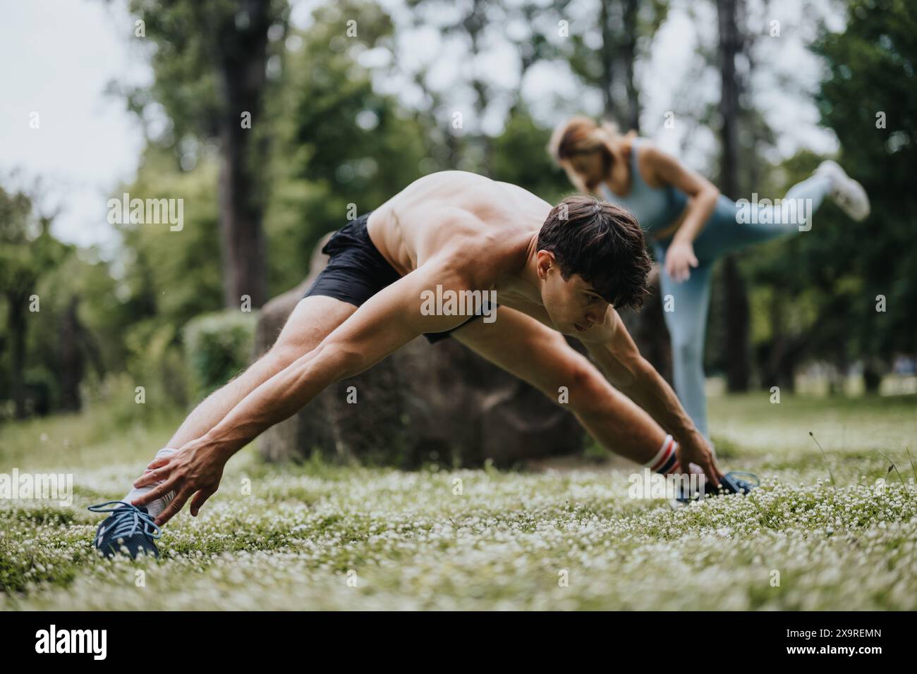 Man and woman doing outdoor stretching exercises in park for warm up ...