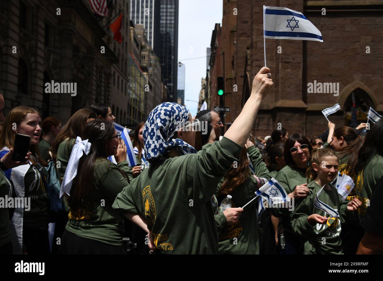 A woman holds up an Israeli flag as she marches in the Israeli Day Parade along Fifth Ave., New