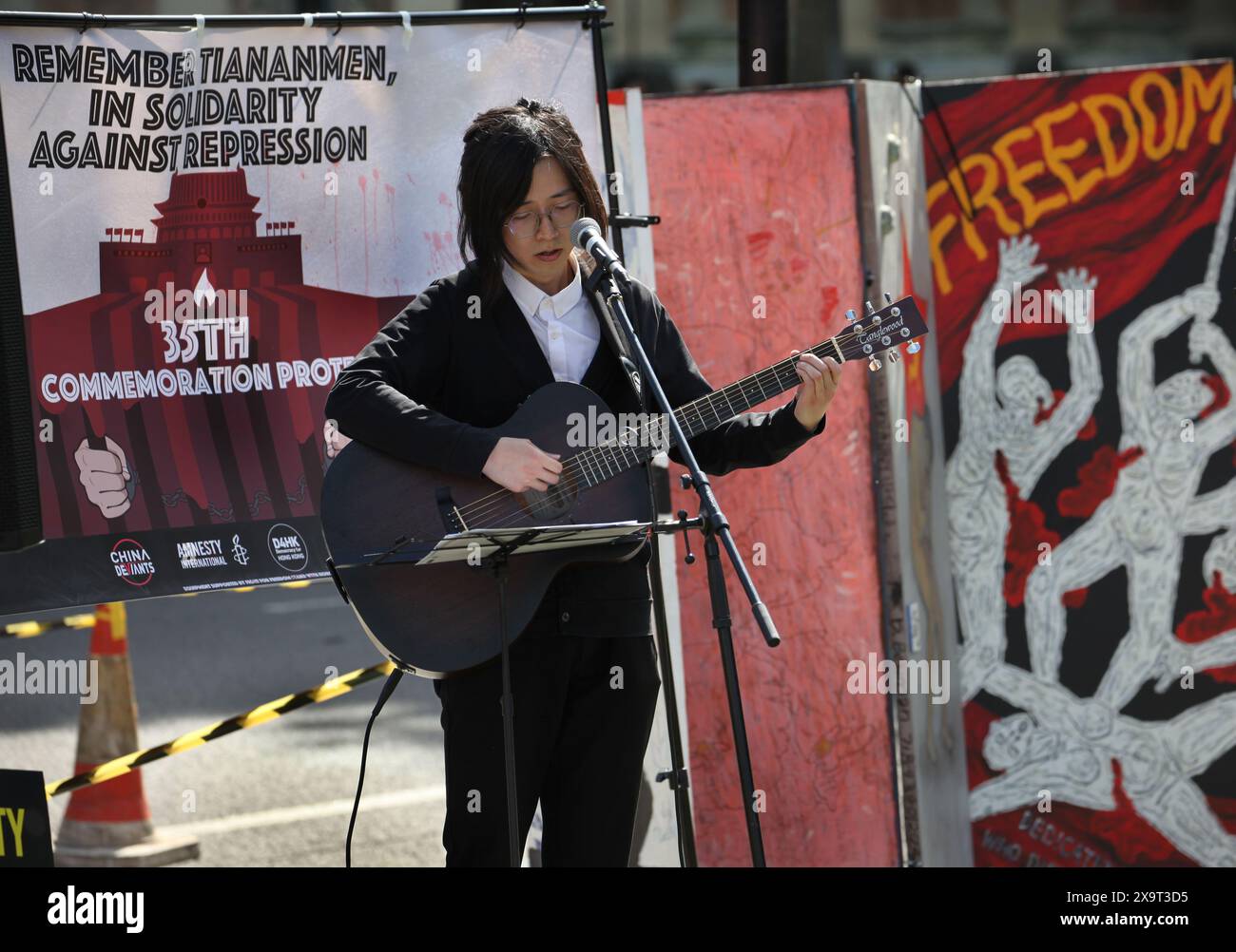 June 2, 2024, London, England, UK: A young musician sings a song with the backdrop of a ''˜Freedom' banner, during the demonstration in Parliament Square. The event commemorated the1989 student-led protests and the Chinese government's bloody crackdown on 4 June, as well as protest against China's current clampdown on freedom of speech - including its increasing repression of Tibetans and Uyghurs, its crushing of dissent in Hong Kong, and the intimidation of Chinese and Hong Kong students in the UK, Europe and North America. Thirty-five years on, the Chinese authorities still ban information Stock Photo