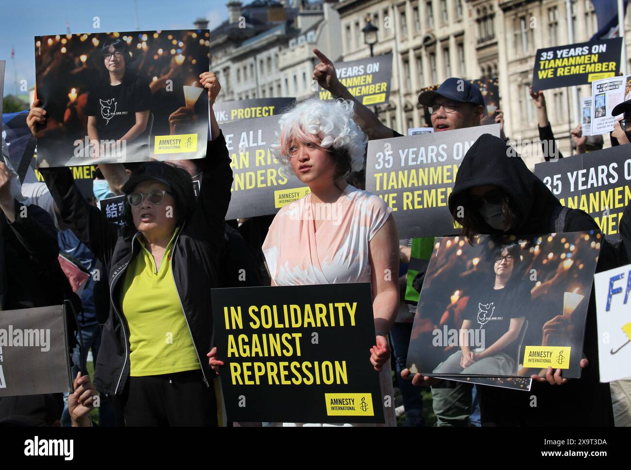 June 2, 2024, London, England, UK: A protester dressed as the Goddess of Democracy holds a sign saying ''˜In Solidarity Against Repression' along with others during the demonstration in Parliament Square. The event commemorated the1989 student-led protests and the Chinese government's bloody crackdown on 4 June, as well as protest against China's current clampdown on freedom of speech - including its increasing repression of Tibetans and Uyghurs, its crushing of dissent in Hong Kong, and the intimidation of Chinese and Hong Kong students in the UK, Europe and North America. Thirty-five years Stock Photo