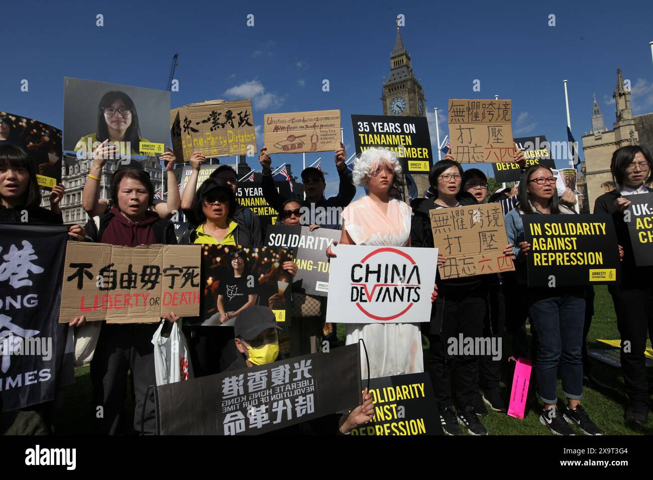 June 2, 2024, London, England, UK: Protesters gather together holding signs supporting their position, one dressed as the Goddess of Democracy and holding a sign supporting dissident group ''˜China Deviants' during the demonstration in Parliament Square. The event commemorated the1989 student-led protests and the Chinese government's bloody crackdown on 4 June, as well as protest against China's current clampdown on freedom of speech - including its increasing repression of Tibetans and Uyghurs, its crushing of dissent in Hong Kong, and the intimidation of Chinese and Hong Kong students in t Stock Photo