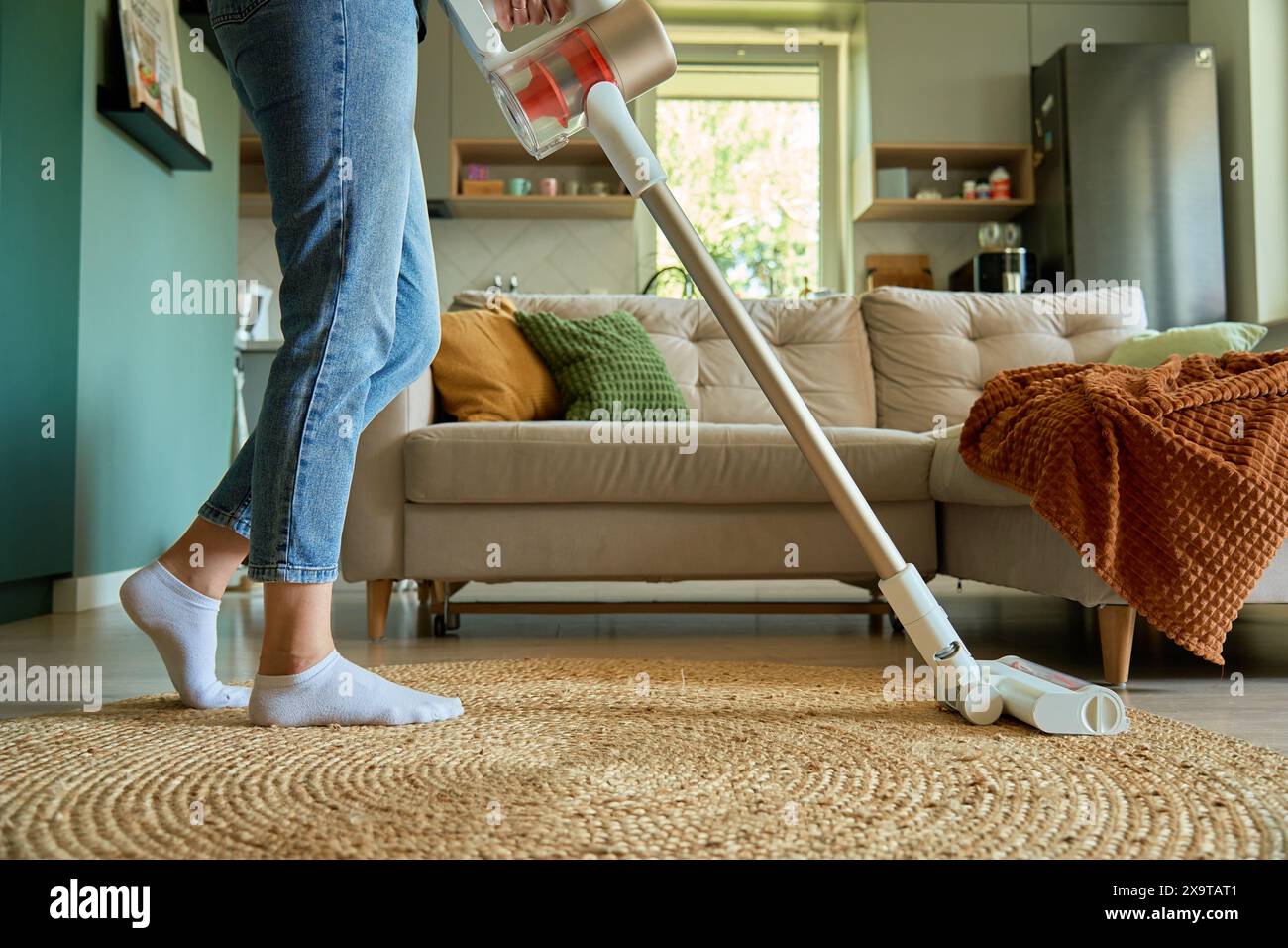 Woman Is Vacuuming Floor Of Modern Apartment Living Room Using woman-is-vacuuming-floor-of-modern-apartment-living-room-using