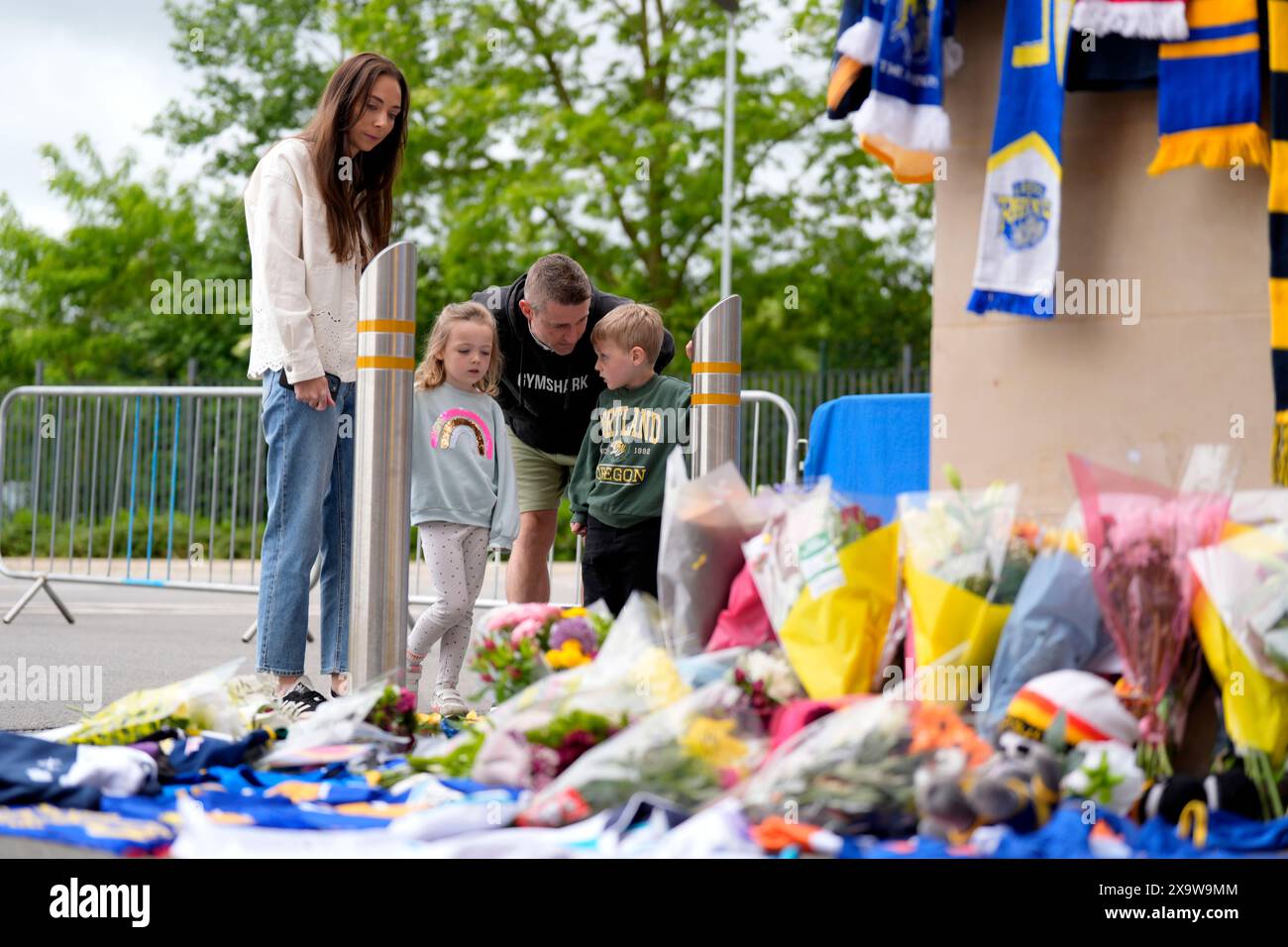 Members of the public pay tribute and view flowers and messages left at ...
