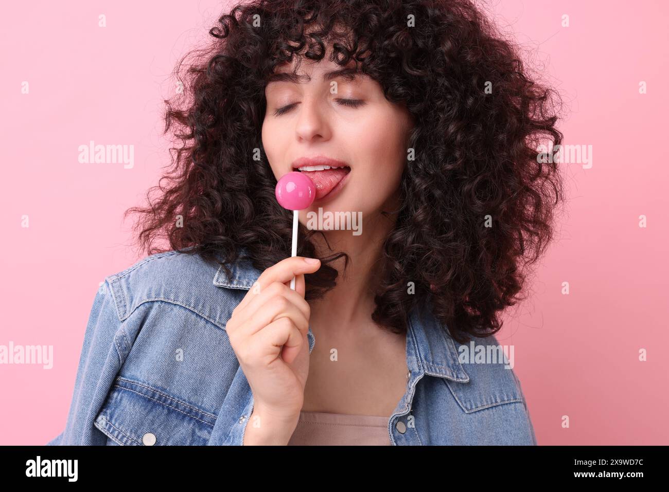 Beautiful woman with lollipop on pink background Stock Photo