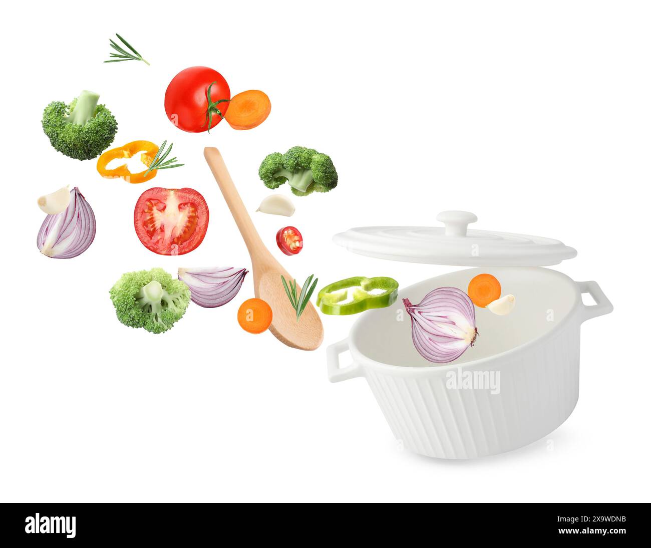 Fresh ingredients falling into saucepan on white background Stock Photo